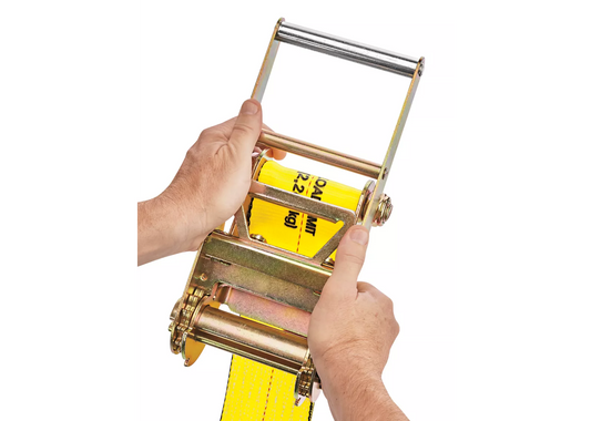 Person using a yellow strap with a ratchet handle on a white background